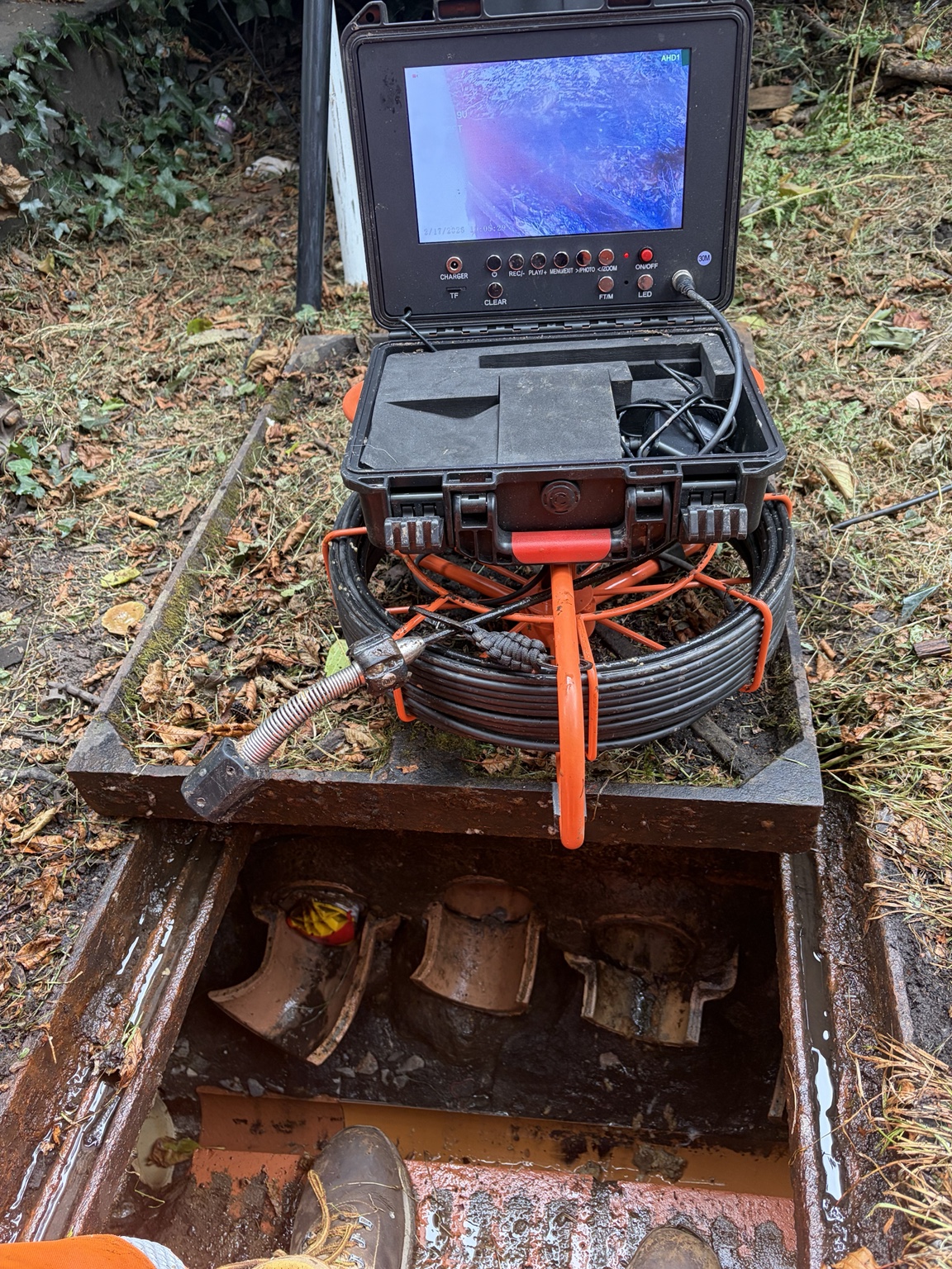 CCTV drain survey equipment positioned over a commercial inspection chamber
